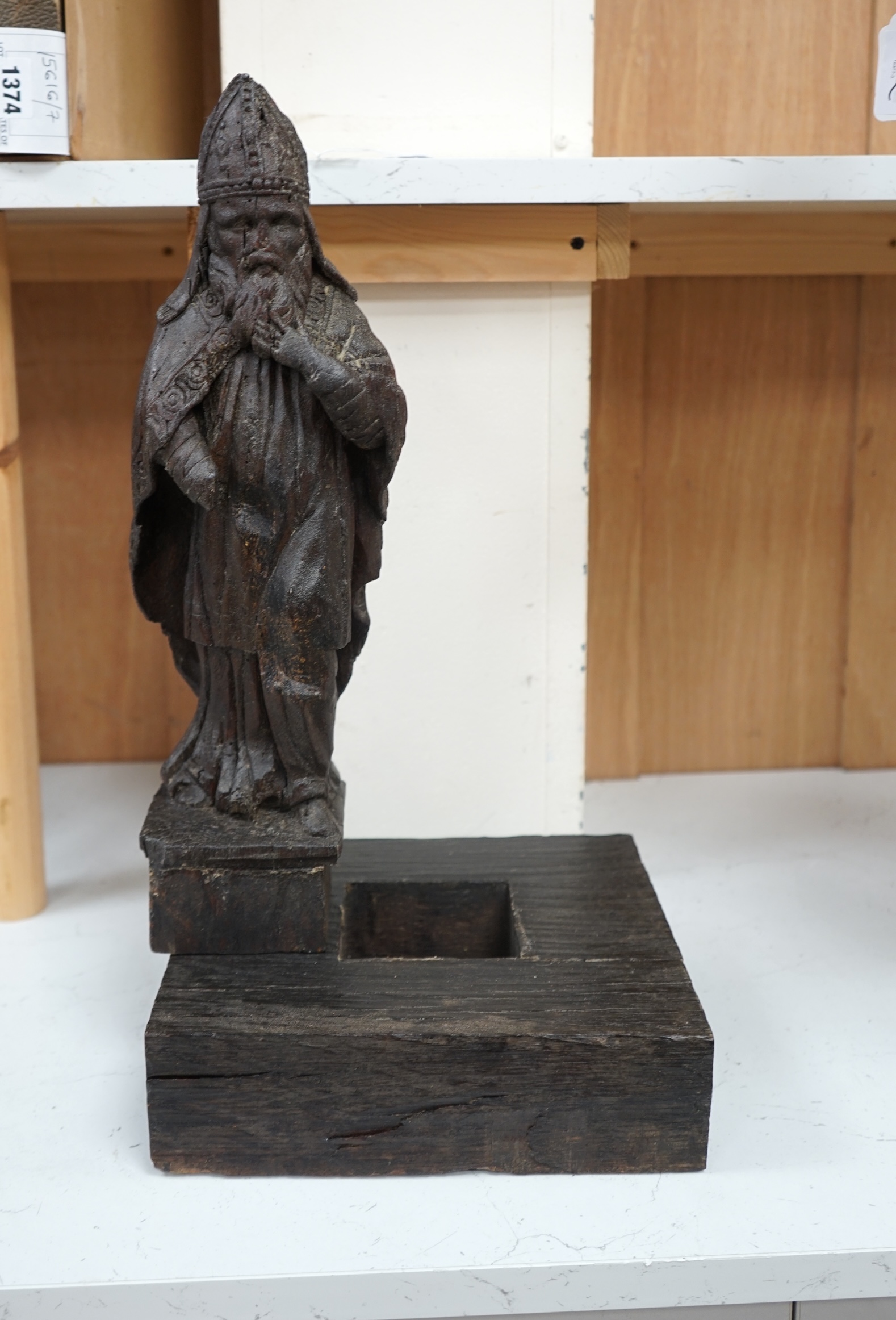 A North European oak carving of a bishop, possibly 17th/18th century, 38cm high not including stand. Condition - poor